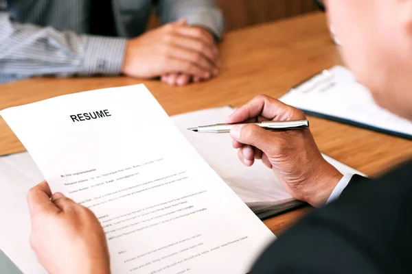 Examiner reading a resume during job interview at office Business and human resources concept.