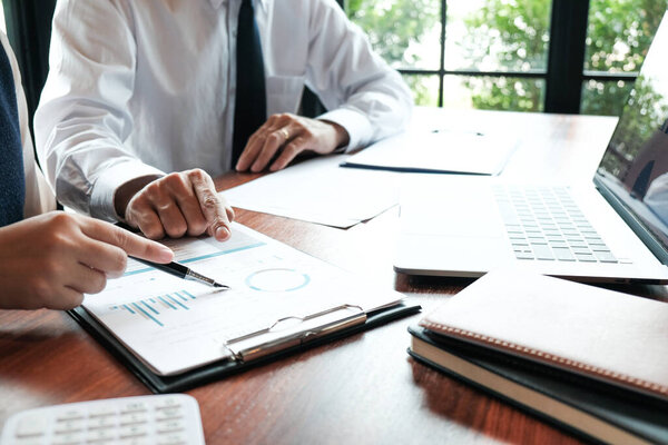 Businessman analyzing investment charts and pressing calculator buttons over documents. Accounting Concept