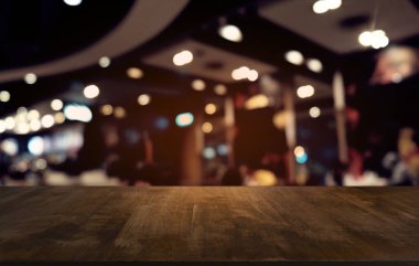 Restoranın soyut bulanık arka planının önündeki boş, siyah ahşap masa. Ürünlerinizi görüntülemek ya da montajlamak için kullanılabilir.