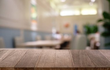 Restoranın soyut bulanık arka planının önündeki boş, siyah ahşap masa. Ürünlerinizi görüntülemek ya da montajlamak için kullanılabilir.