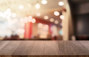 Restoranın soyut bulanık arka planının önündeki boş, siyah ahşap masa. Ürünlerinizi görüntülemek ya da montajlamak için kullanılabilir.