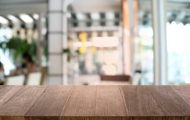 Restoranın soyut bulanık arka planının önündeki boş, siyah ahşap masa. Ürünlerinizi görüntülemek ya da montajlamak için kullanılabilir. 