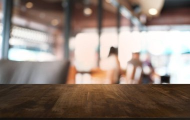 Restoranın soyut bulanık arka planının önündeki boş, siyah ahşap masa. Ürünlerinizi görüntülemek ya da montajlamak için kullanılabilir. 