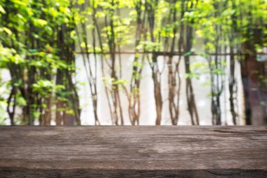 Açık hava bahçe ışıklarının soyut bulanık arka planının önündeki ahşap masa resmi. Ürünlerinizi görüntülemek veya montajlamak için kullanılabilir. Ürünün görüntülenmesi için modelleyin.