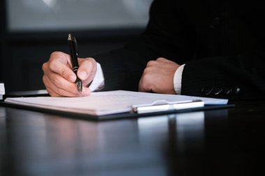 Yatırım çizelgelerini analiz eden ve belgelerin üzerindeki hesap makinesi tuşlarına basan bir işadamı. Muhasebe Kavramı