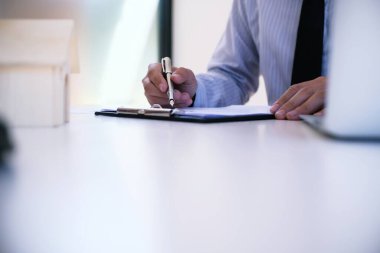 Satış müdürü, araba ve ev sigortası için ipotek kredisi teklifini göz önünde bulundurarak, tavsiye başvuru formu belgesi veriyor