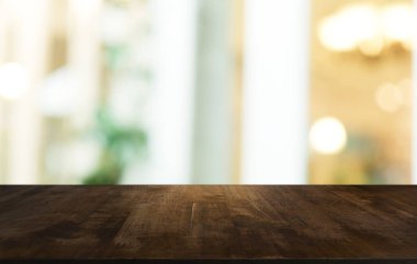 Restoranın soyut bulanık arka planının önündeki boş, siyah ahşap masa. Ürünlerinizi görüntülemek ya da montajlamak için kullanılabilir. 