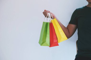 Asyalı kızlar ellerinde alışveriş torbaları tutuyor. Alışveriş merkezinde tüketim yaşam tarzı kavramı