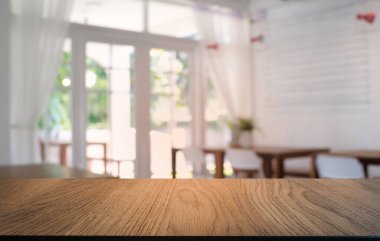 Restoranın soyut bulanık arka planının önündeki boş, siyah ahşap masa. Ürünlerinizi görüntülemek ya da montajlamak için kullanılabilir. 