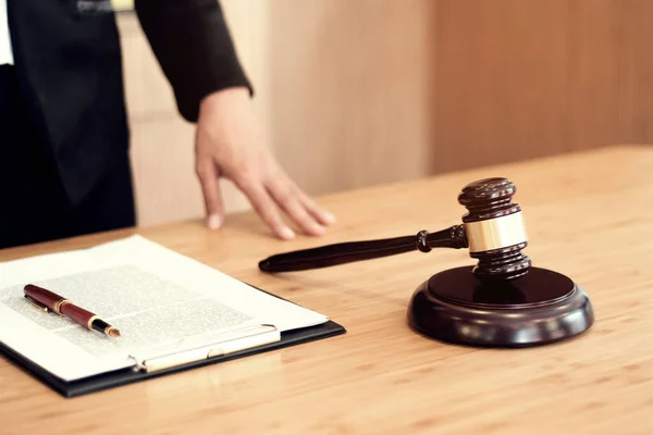 Hukuk danışmanı müvekkiline tokmak ve hukuk hukuku ile imzalanmış bir sözleşme sunar. Adalet ve avukat kavramı