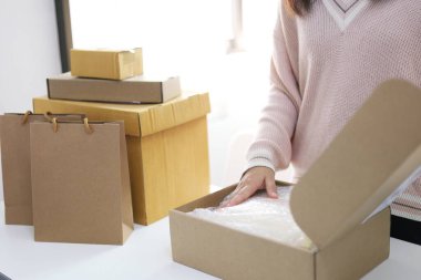 Home Woman 'dan gelen iş kadını, çevrimiçi alışveriş için paket teslimat kutusu hazırlıyor. gençler online siparişte küçük işletme sahibi olarak başlıyorlar 