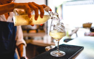 Uzman barmen gece kulübünde alkollü kokteyl hazırlıyor. Profesyonel barmen kokteyl hazırla.