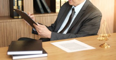 Hukuk danışmanı müvekkiline tokmak ve hukuk hukuku ile imzalanmış bir sözleşme sunar. Adalet ve avukat kavramı