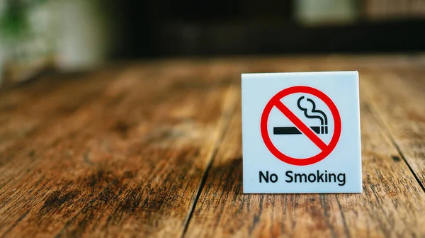 Do not smoke sign. No Smoking label in the public. No smoking sign on wood table at hotel