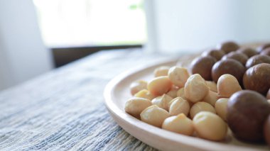 Organik Macadamia fındığı. Macadamia fındıkları son derece lezzetli süper yiyecekler, taze doğal kabuklu macadamia ve sağlıklı besin konsepti tatmak için kırılıp pişirilir.