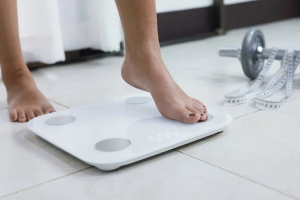 足は体重管理のため電子スケールに立っています ダイエットコントロールのためのキログラムで測定器 — ストック写真