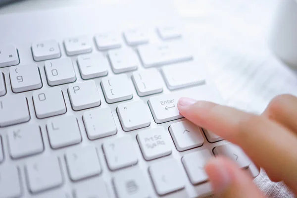 Hands of business woman Index finger pressing enter button on computer keyboard