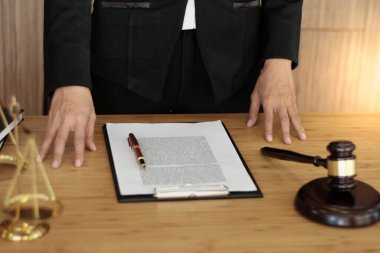 Hukuk danışmanı müvekkiline tokmak ve hukuk hukuku ile imzalanmış bir sözleşme sunar. Adalet ve avukat kavramı