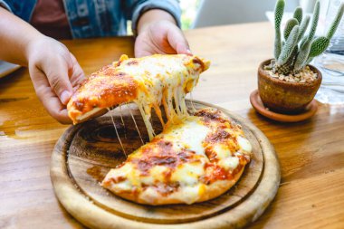 Bir dilim taze, peynirli vejetaryen pizza mozzarella peyniri. İtalyan eritme peyniri elinde pizza margherita