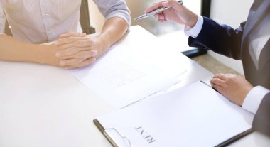 Satış müdürü, araba ve ev sigortası için ipotek kredisi teklifini göz önünde bulundurarak, tavsiye başvuru formu belgesi veriyor