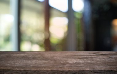 Restoranın soyut bulanık arka planının önündeki boş, siyah ahşap masa. Ürünlerinizi görüntülemek ya da montajlamak için kullanılabilir. 