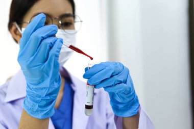 Coronavirus covid-19 'u tutan bilim adamı enfekte olmuş kan örneği tüpü. Kan örneği toplama tüpleri ve şırınga Coronavirus Covid-19 aşı araştırmalarıyla laboratuvardaki kanın DNA testi.