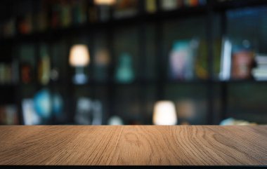 Kafenin soyut bulanık arka planının önündeki boş ahşap masa. Öndeki ahşap tablo ürünlerinizi görüntülemek veya montajlamak için kullanılabilir. Produc gösterimi için modelleyin
