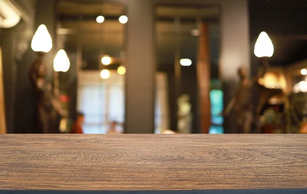 Empty wooden table in front of abstract blurred background of coffee shop . wood table in front can be used for display or montage your products.Mock up for display of produc