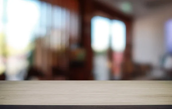 Empty wooden table in front of abstract blurred background of coffee shop . wood table in front can be used for display or montage your products.Mock up for display of produc