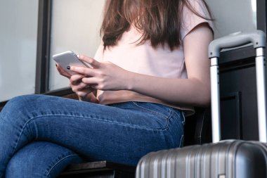 Genç ve güzel bir bayan gezgin akıllı telefon kullanıyor. 