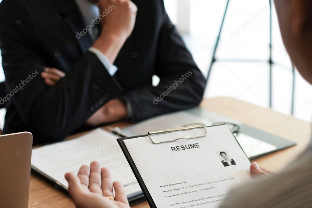 Examiner reading a resume during job interview at office Business and human resources concept.