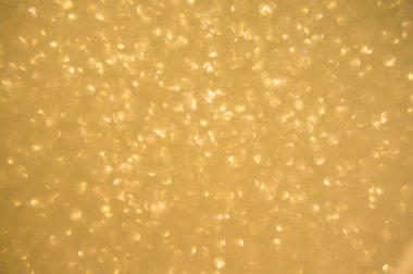 Altın arka planda parıldar. Işıldayan bulanık spot ışıkları Bokeh parlak altın arkaplan dokusu