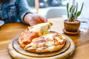 Bir dilim taze, peynirli vejetaryen pizza mozzarella peyniri. İtalyan eritme peyniri elinde pizza margherita