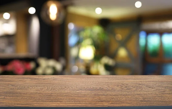 Empty wooden table in front of abstract blurred background of coffee shop . wood table in front can be used for display or montage your products.Mock up for display of produc