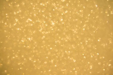 Altın arka planda parıldar. Işıldayan bulanık spot ışıkları Bokeh parlak altın arkaplan dokusu