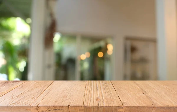 Empty wooden table in front of abstract blurred background of coffee shop . wood table in front can be used for display or montage your products.Mock up for display of produc