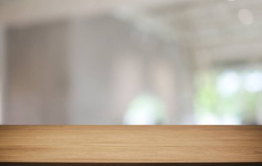 Kafenin soyut bulanık arka planının önündeki boş ahşap masa. Öndeki ahşap tablo ürünlerinizi görüntülemek veya montajlamak için kullanılabilir. Produc gösterimi için modelleyin