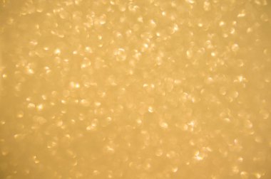 Altın arka planda parıldar. Işıldayan bulanık spot ışıkları Bokeh parlak altın arkaplan dokusu