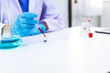 Coronavirus covid-19 'u tutan bilim adamı enfekte olmuş kan örneği tüpü. Kan örneği toplama tüpleri ve şırınga Coronavirus Covid-19 aşı araştırmalarıyla laboratuvardaki kanın DNA testi.