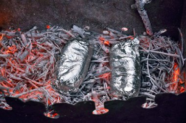 Folyodaki sosisler kömür ızgarasının üstünde pişirilir.