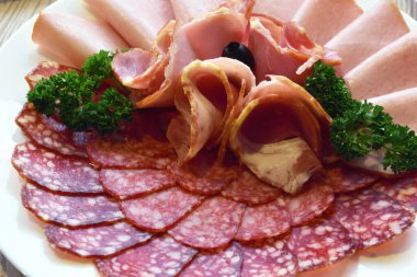 Sosis ve tütsülenmiş et şeklinde dilimlenmiş soğuk aperatifler güzel bir ziyafetin üzerine serilmiştir.