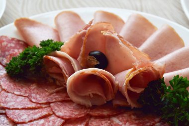 Sosis ve tütsülenmiş et şeklinde dilimlenmiş soğuk aperatifler güzel bir ziyafetin üzerine serilmiştir.