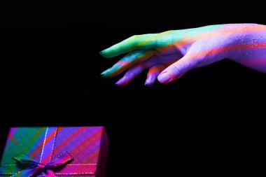 Güzel, çok renkli bir kadın elini uzatır.