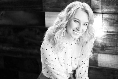 Güzel, genç, gülümseyen mutlu bir kadının siyah beyaz portresi ahşap arka planda, bir uzmanın iş portresi.