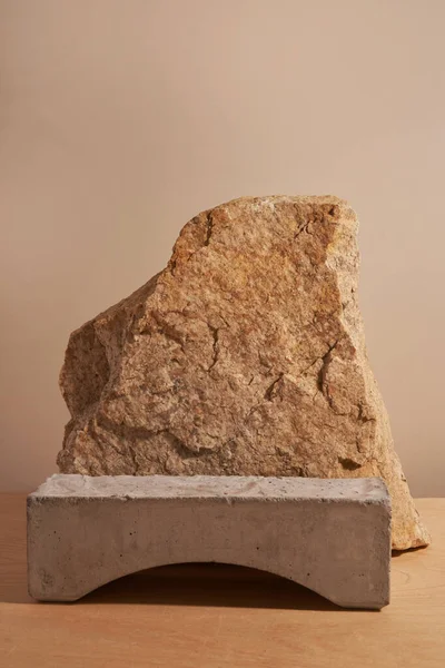 Piedra y un trozo de azulejo podio sobre un fondo beige Fotos de stock libres de derechos