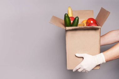  Lastik eldivenli beyaz kuryenin ellerinde bir kutu yiyecek, fast-and-food teslimatı..