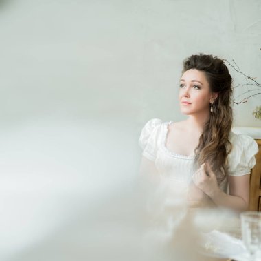 Beyaz elbiseli, uzun saçlı güzel bir kadının klasik portresi.. 