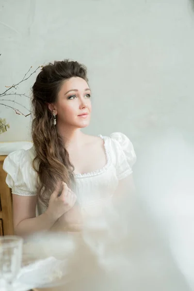 Retrato vintage de mujer hermosa con pelo largo en vestido blanco, mira hacia otro lado. Imagen de stock