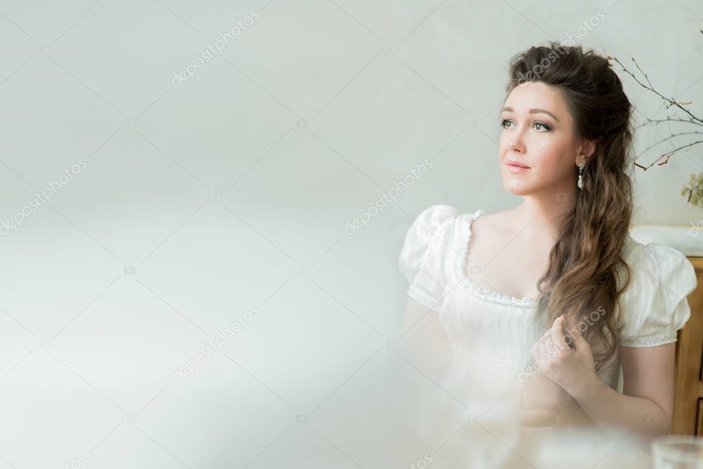 Vintage portrait of beautiful woman with long hair in white dress, looks away. 