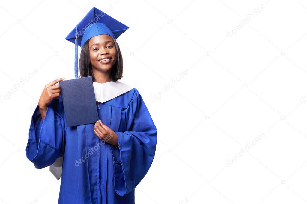 Black woman in a blue robe on a white background smiles and shows diploma